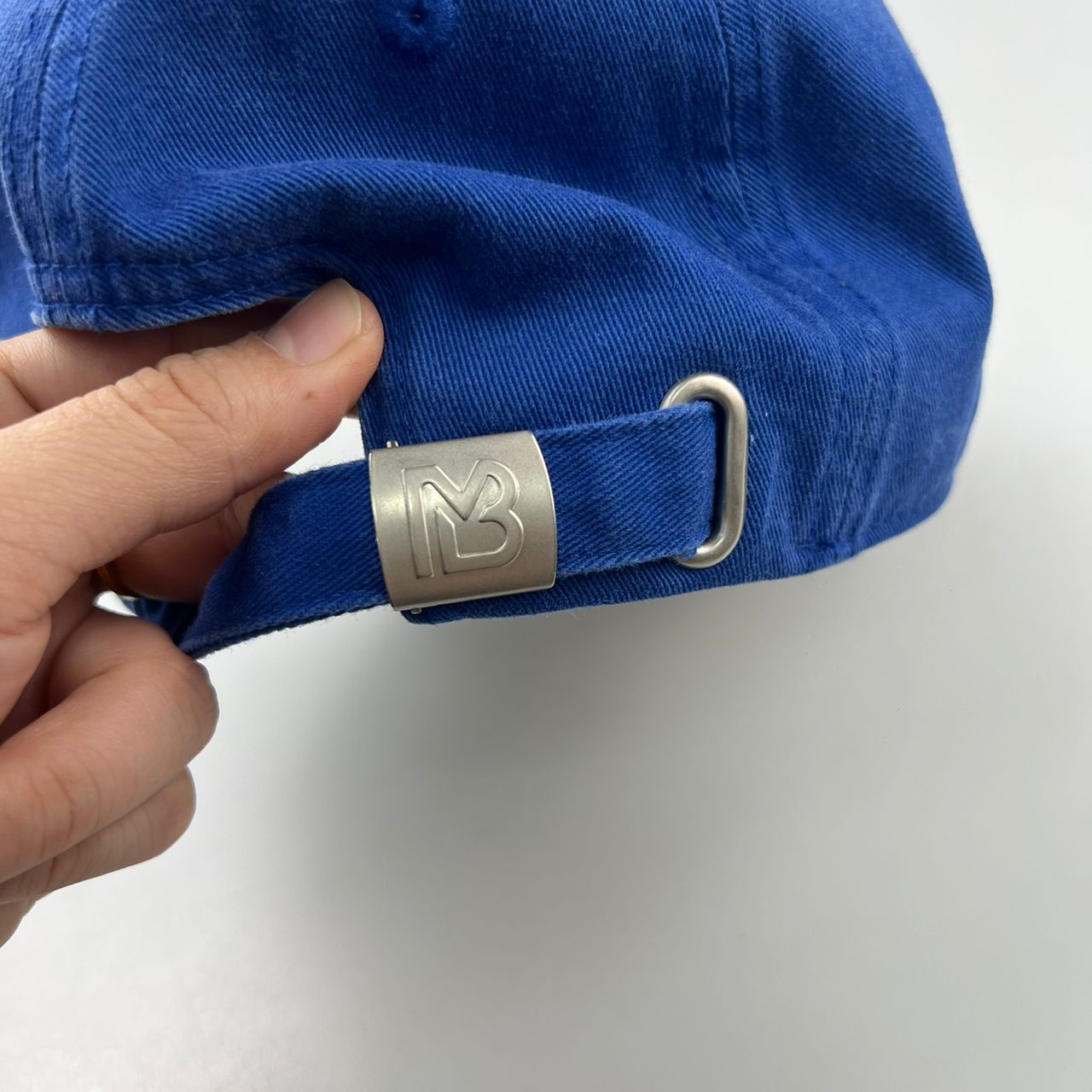 Dettaglio della fibbia metallica posteriore con monogramma MB